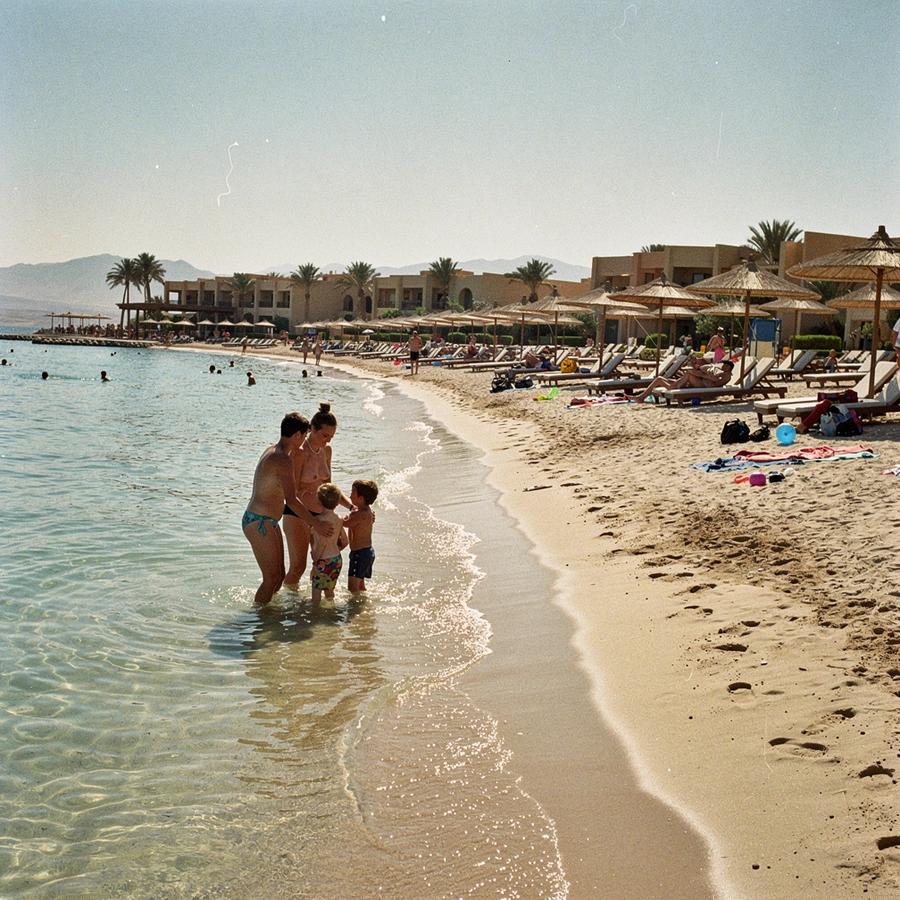 Family beach at a Red Sea resort with shallow entry and rows of parasols at midday